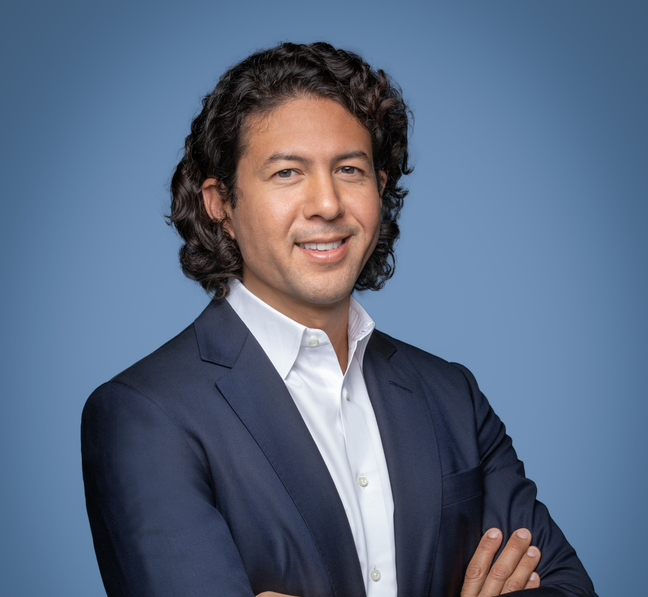 Rashad Kussad, Meridor CEO, in a navy suit with arms folded against a blue backdrop