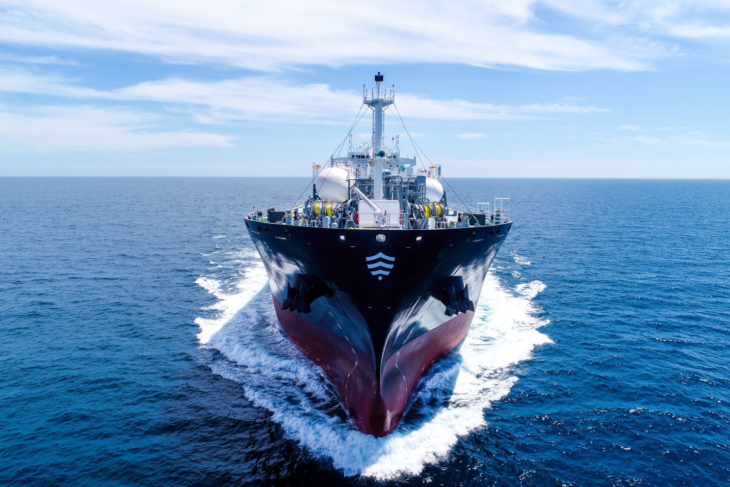 Газовоз анфас: нос разрезает волну в открытом море, на борту волновой знак Meridor